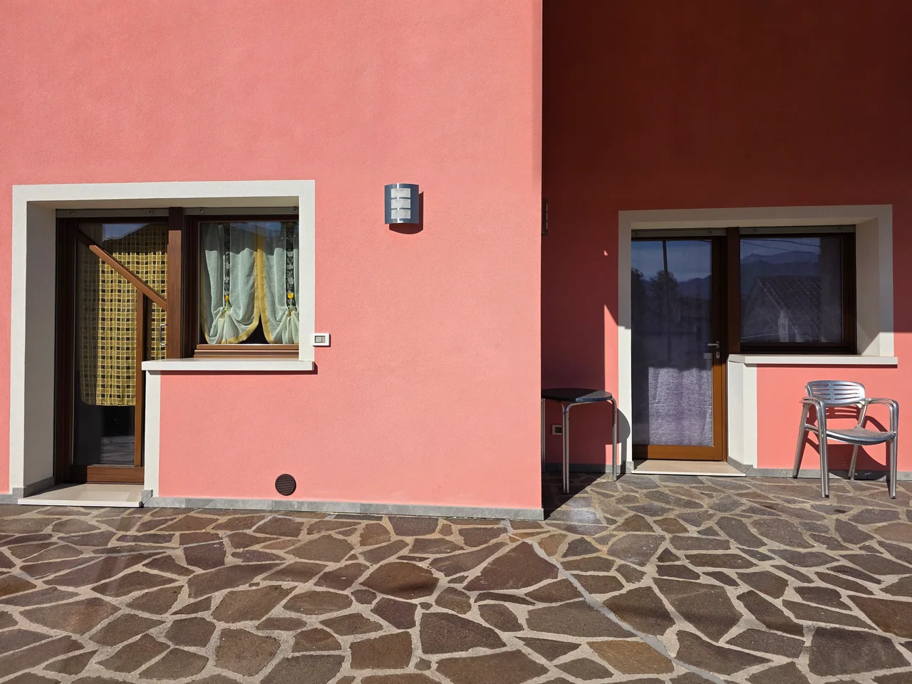 L’ingresso dell’appartamento è la portafinestra con tenda gialla, a sinistra. Si raggiunge senza scale. La locazione riguarda esclusivamente il piano terra.